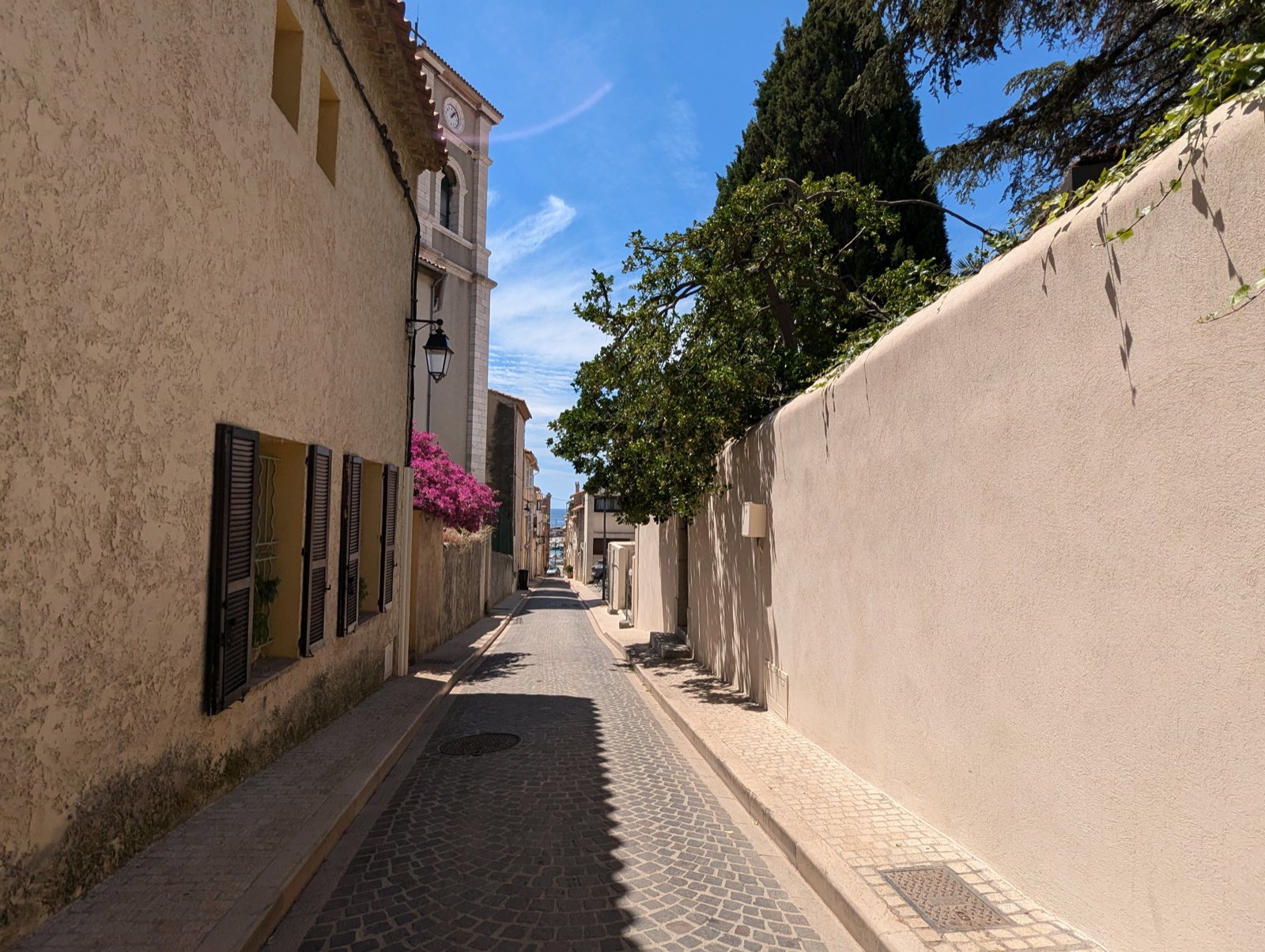 Une ruelle du village de Cassis, clocher et façades provençales, échappée vers le port